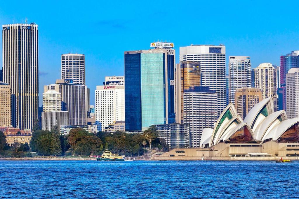 einen Blick auf das Sydney Opera House und die Stadt in der Unterkunft Sydney Harbour Marriott Hotel at Circular Quay in Sydney