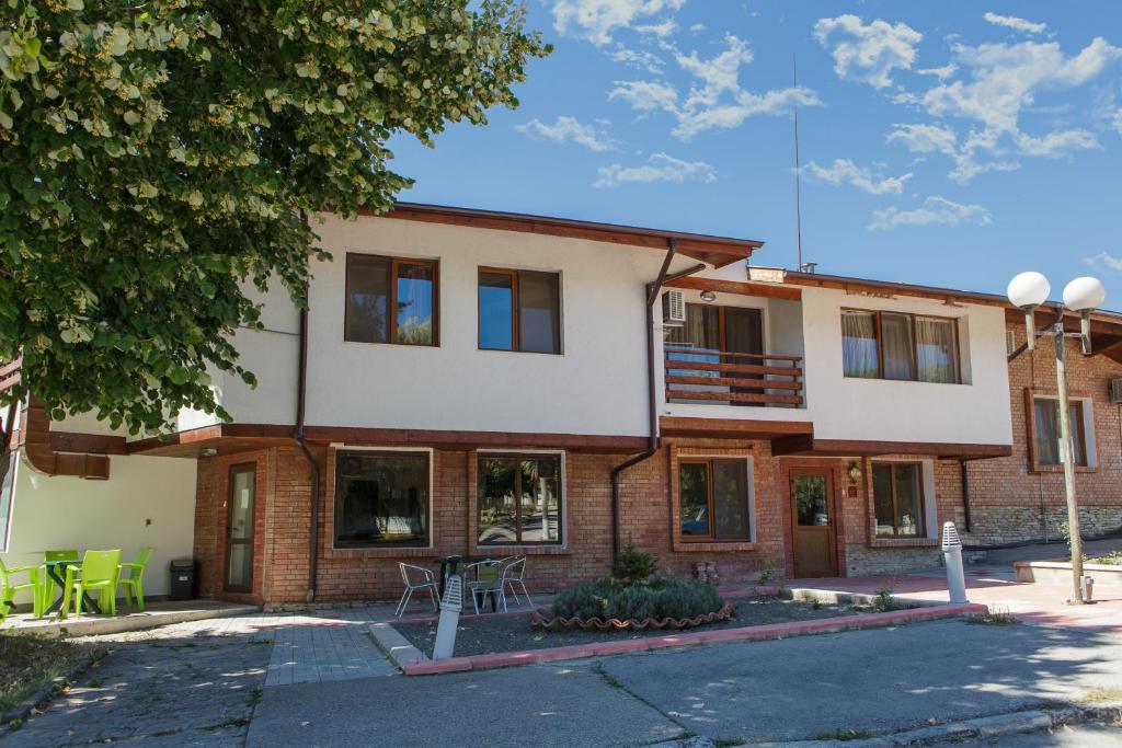 a brick building with a table and chairs in front of it at Family Hotel Kipra in Kipra