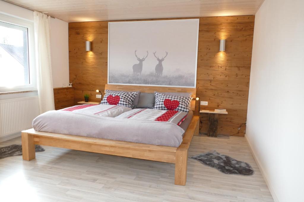 una camera da letto con un grande letto con cuscini rossi di FLAIR Bad Rodach - 5 Sterne Ferienwohnungen a Bad Rodach
