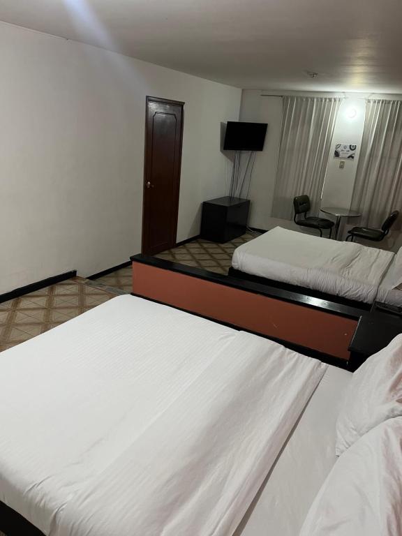 Habitación de hotel con 2 camas y TV en Way Maker 1, en Bogotá