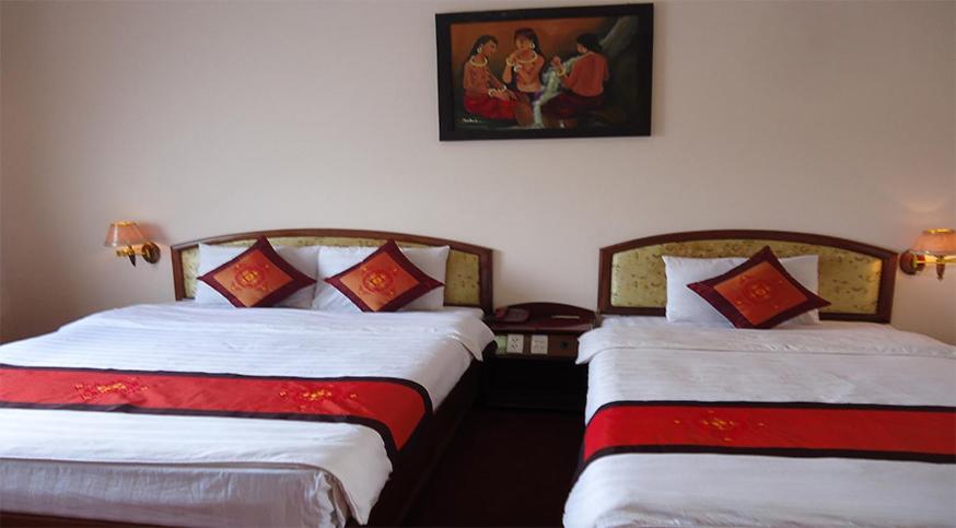 two beds sitting next to each other in a room at Sepon Hotel in Lao Bao