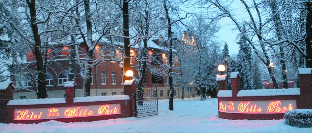 a building covered in snow with lights on it at Hotel Willa Park in Żagań
