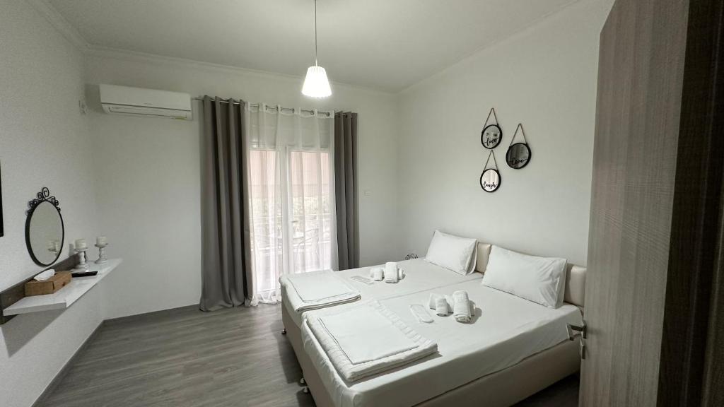 a white bedroom with a bed and a mirror at Kris boy in Athens