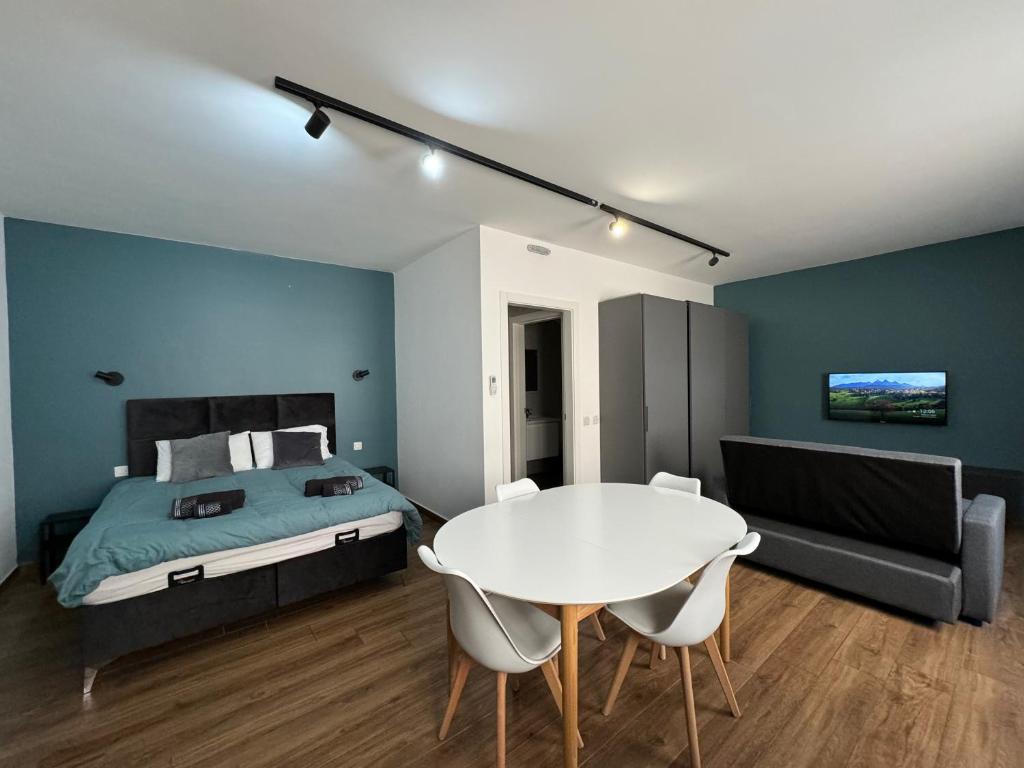 普若佛的住宿－Capital Heights Suite, Victoria，卧室配有床和白色的桌椅