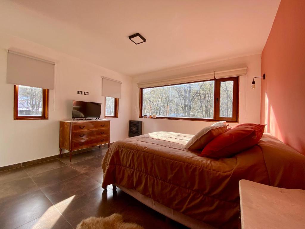um quarto com uma cama e uma grande janela em Bosques de ñires em Ushuaia
