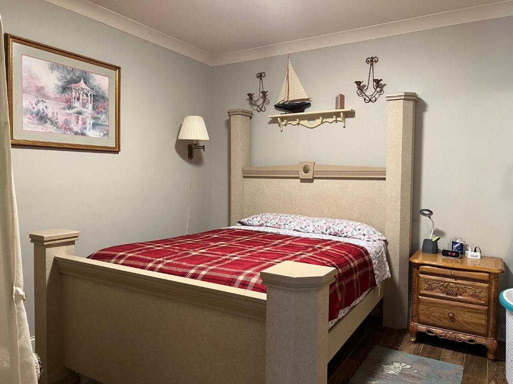 1 dormitorio con 1 cama con manta de cuadros roja en Private Entrance Cozy Room at Heart of Chattanooga en Chattanooga