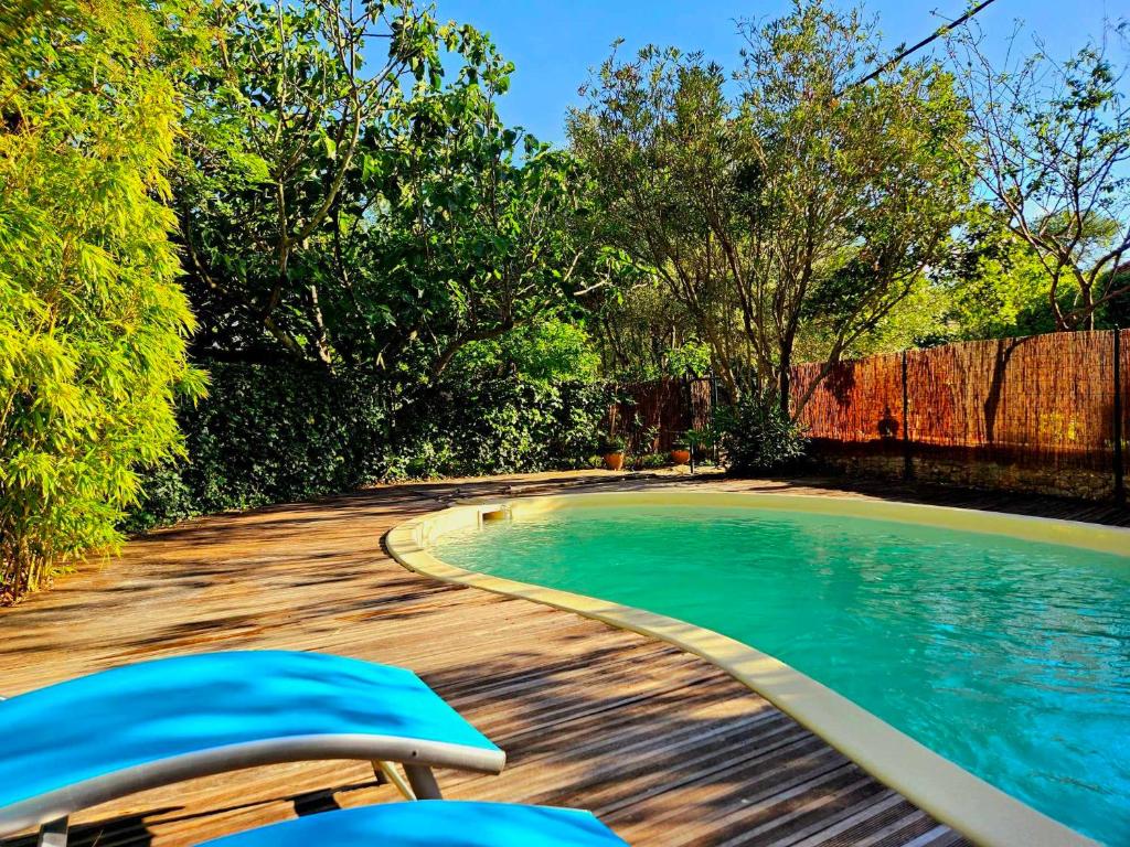 - une piscine avec 2 chaises à côté dans l'établissement Chambre d'hôtes Les Berges de l'Aude - B&B - Proche Canal du midi & Carcassonne, à Puicheric