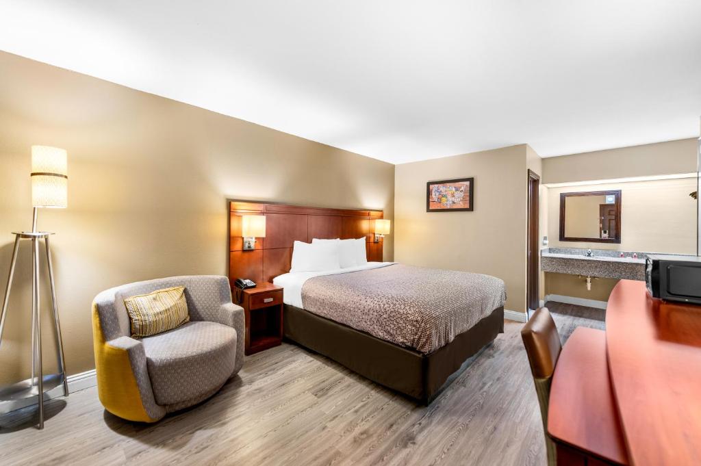 Pokój hotelowy z łóżkiem i krzesłem w obiekcie Econo Lodge Texarkana I-30 w mieście Texarkana