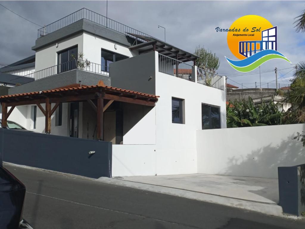Biały dom z napisem na boku w obiekcie Vаrаndаs dо Sоl-Vista relaxante entre mar e montanha w mieście Ponta do Sol