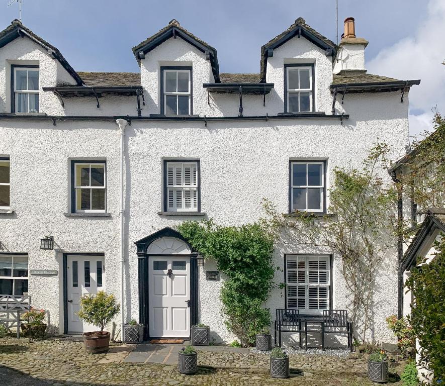 a white brick house with a white door at Ross Cottage in Hawkshead