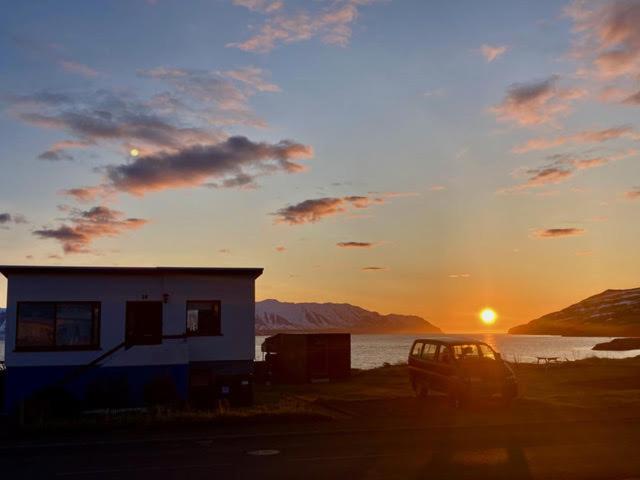 uma casa e um carro estacionados em frente a um pôr-do-sol em Borg Grenivik em Grenivík