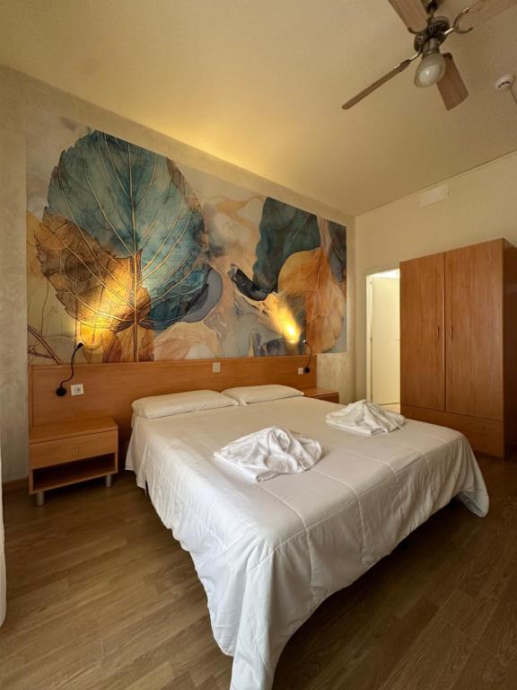LA MAISON by Hotel Aldebaran في ليدو دي يسولو: غرفة نوم بسرير ودهان مظلات