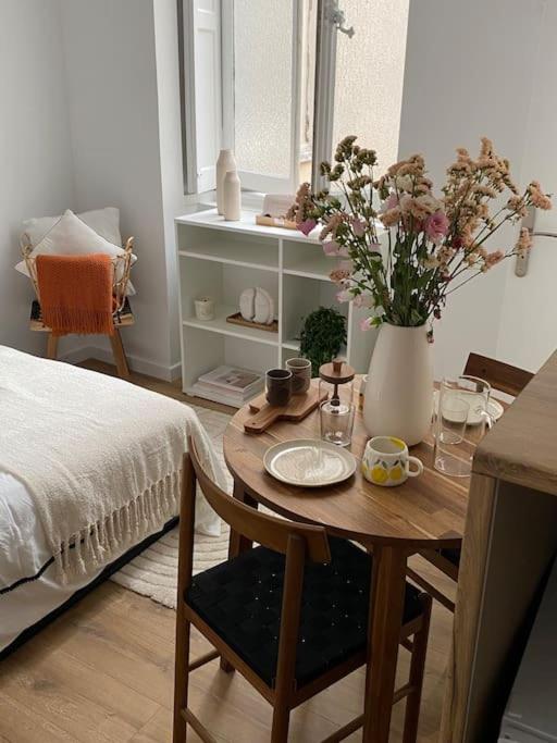 - une chambre avec une table et un vase de fleurs dans l'établissement Appartement Plein Centre, à Lyon