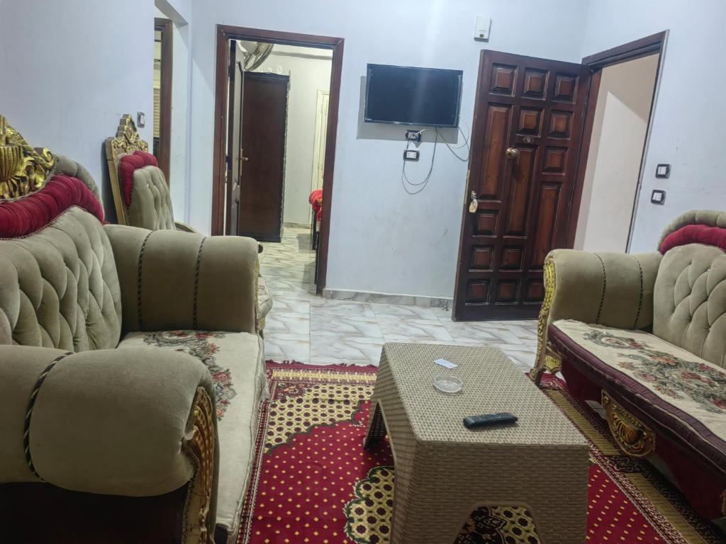 a living room with couches and a table and a tv at kelany home in Siwa