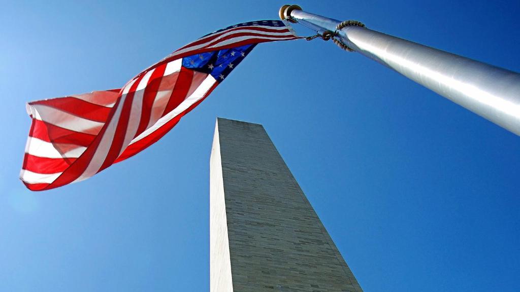 Una bandiera americana che batte vicino al monumento di Washington. di Holiday Inn Express Fairfax-Arlington Boulevard, an IHG Hotel a Fairfax