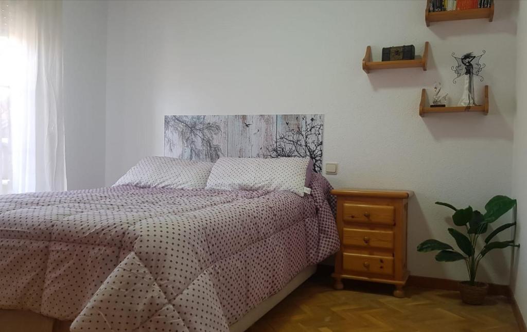 a bedroom with a bed and a table with a plant at Enjoy Tietar in Sotillo de la Adrada