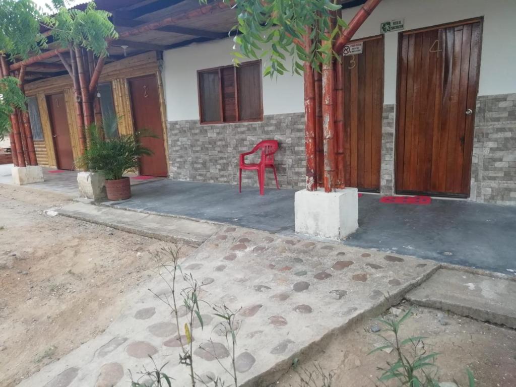 una casa con una sedia rossa su un patio di La Guaca a Villavieja