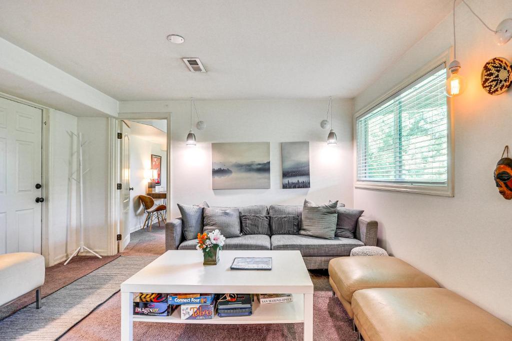 ein Wohnzimmer mit einem Sofa und einem Tisch in der Unterkunft Lush Portland Flat with Fire Pit, 4 Mi to Dtwn! in Portland