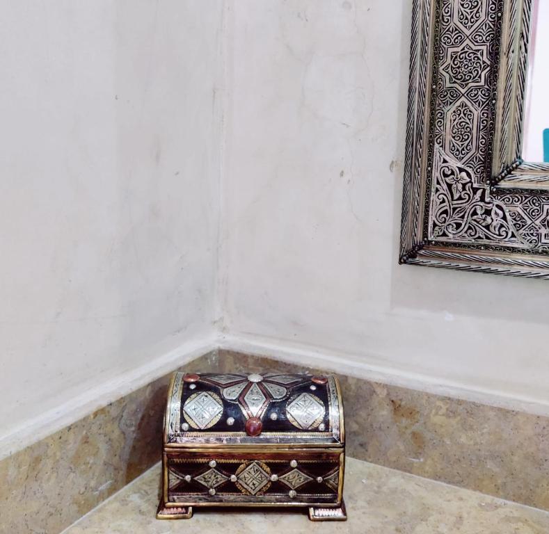 une boîte assise sur le sol à côté d'un miroir dans l'établissement Zagora Oasis Lodge, à Zagora