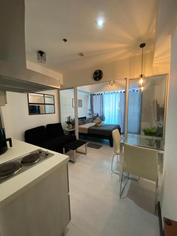 a kitchen and living room with a couch and a table at LizJen Staycation at Azure Urban Resort in Manila