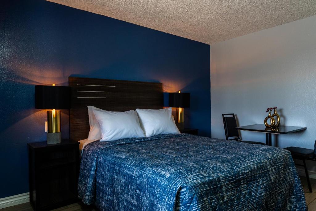 una camera con un letto con una parete blu di Pala Motel a Pomona