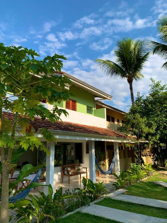 a house with a hammock in front of it at Pousada Recanto Itaguá in Ubatuba
