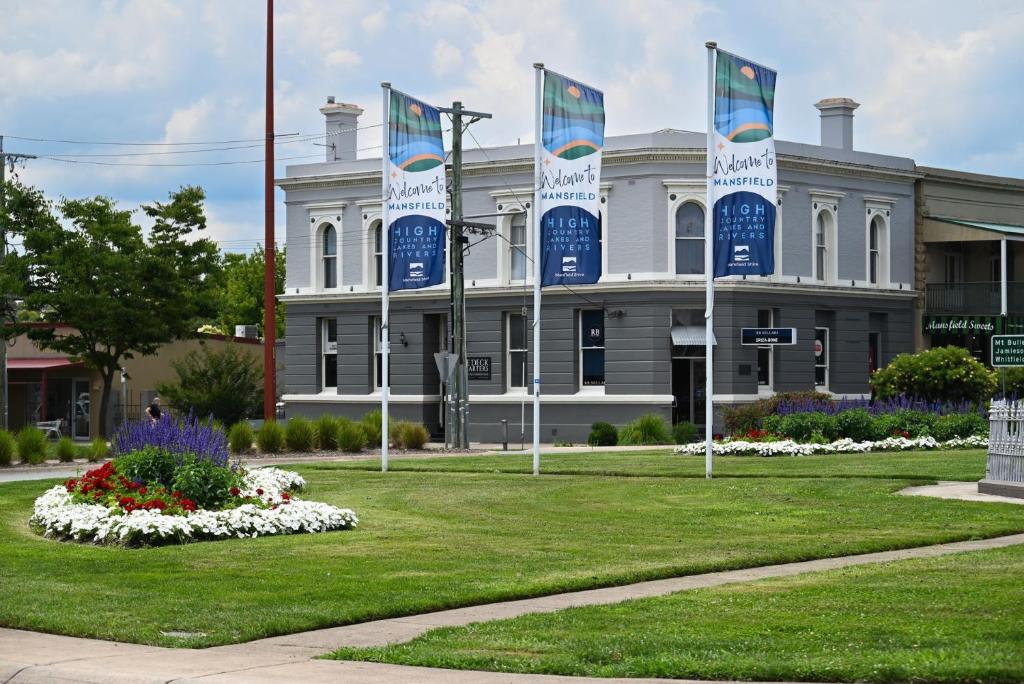 un bâtiment arborant des drapeaux bleus et blancs devant lui dans l'établissement Deck Quarters - Mansfield, à Mansfield