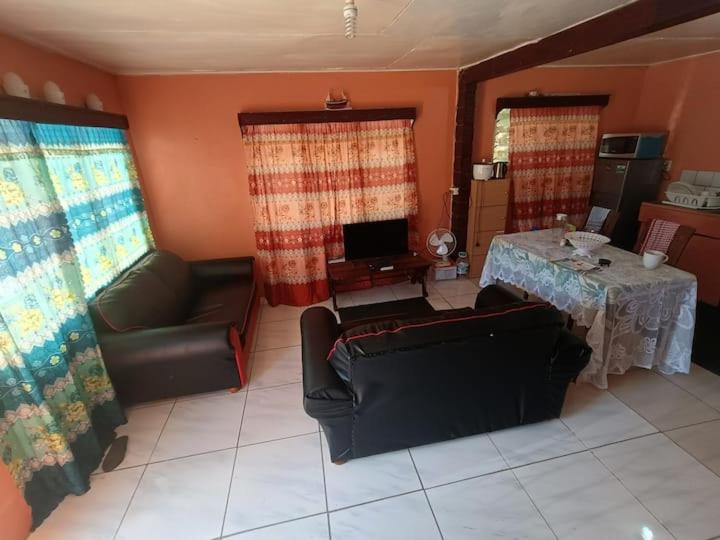 uma sala de estar com uma mesa, um sofá e uma secretária em Kapeta Cabin em Hofoa