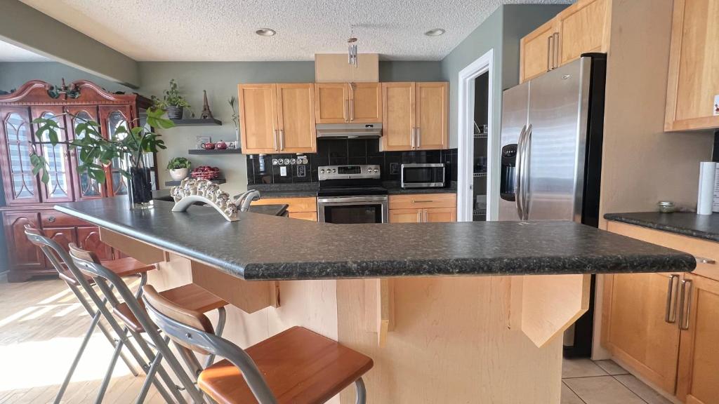 a kitchen with a black counter top and wooden cabinets at Private Room Male Only North Side Edmonton 165 Ave 56 Street Walking Distance to Strip Mall in Edmonton