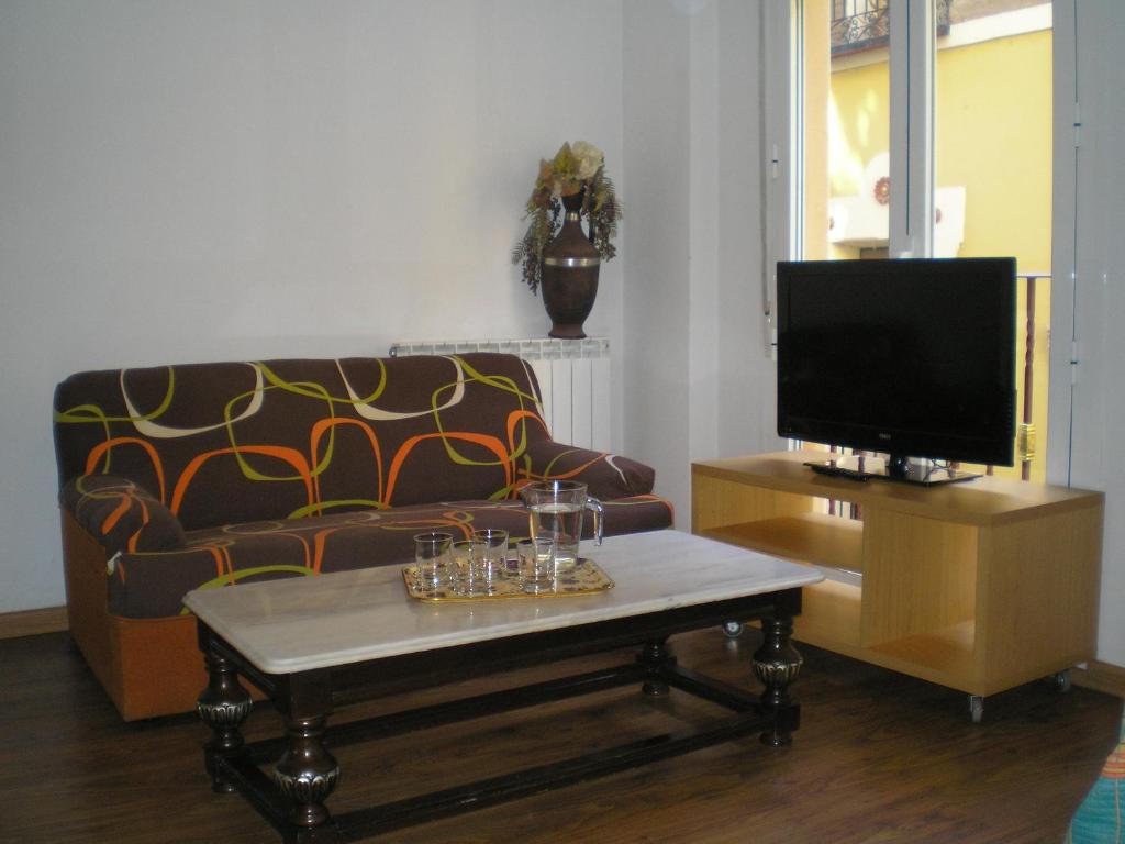 a living room with a couch and a coffee table at Apartamentos Turísticos Reyes Católicos in Zaragoza