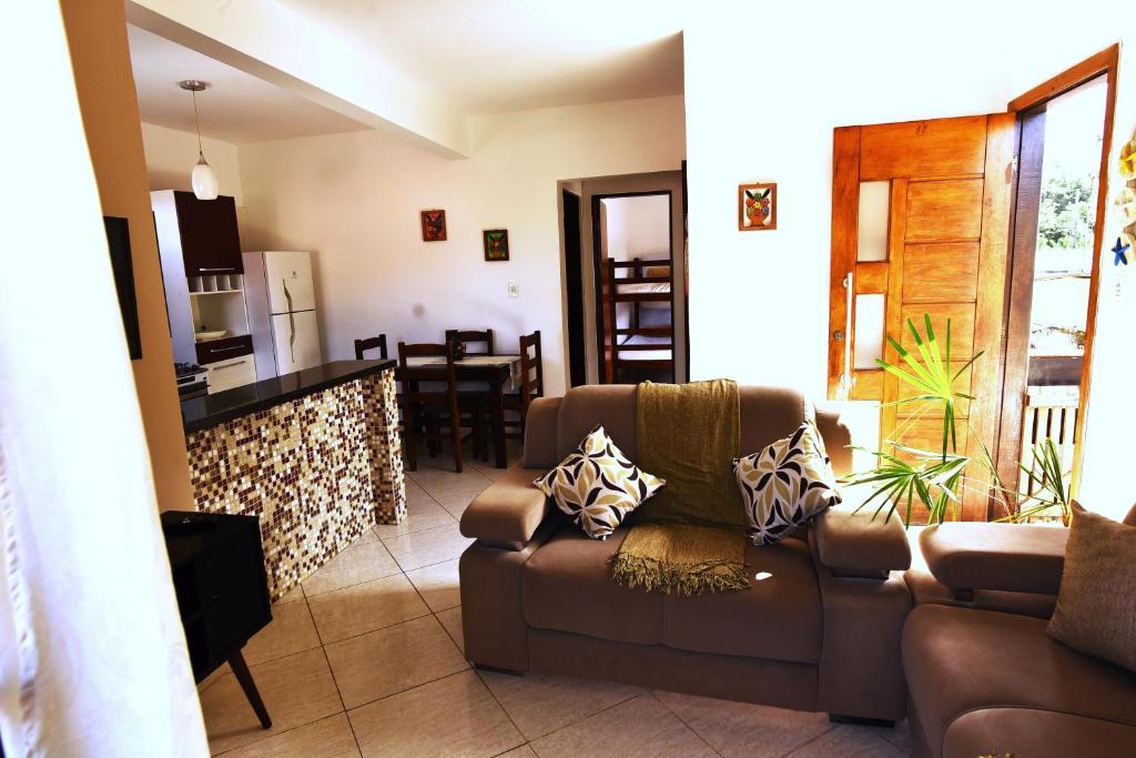 a living room with a couch and a kitchen at Apto bem equipado, com 2 quartos acomoda até 6 pessoas confortavelmente in Ubatuba
