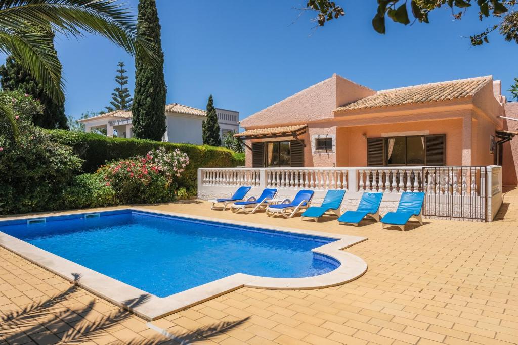 een zwembad met stoelen en een huis bij Vila Telo in Luz