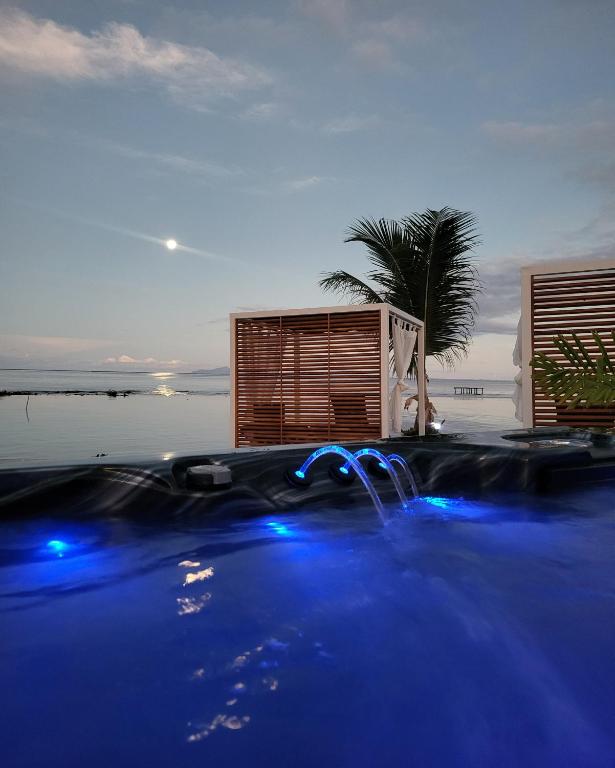 - une piscine avec des lumières bleues dans un complexe dans l'établissement Pension Irivai, appartement UO UO 3 chambres vue mer, à Uturoa