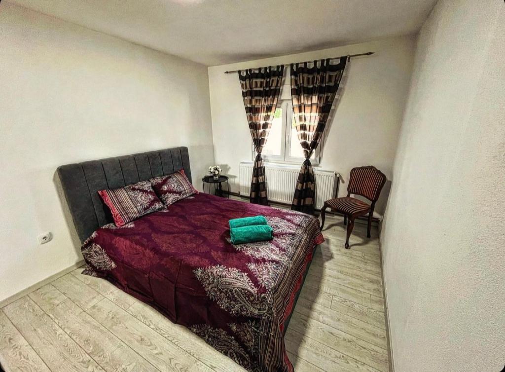 a bedroom with a bed and a chair and a window at Beli Dvor na Dunavu in Kovin