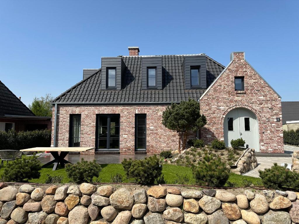 una casa di mattoni con un muro di pietra di fronte di Einzelhaus Huus Elphi Huus Elphi a Tating