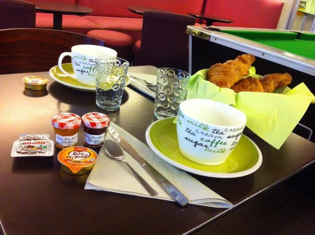 una mesa con dos tazas y un plato de comida en Le Thy, en Ploërmel