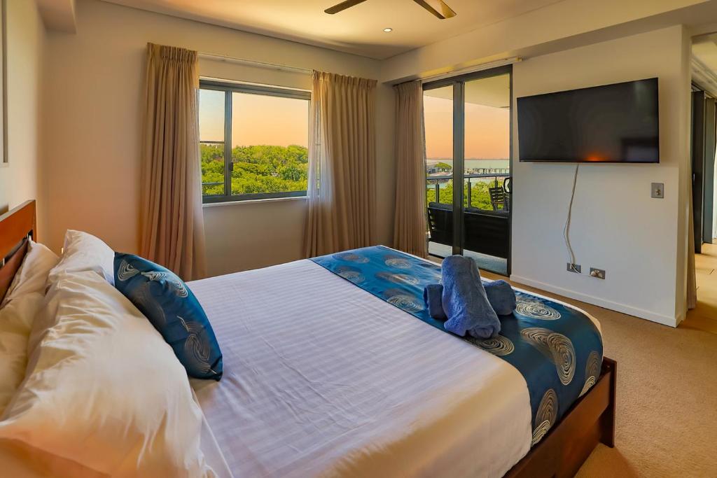 a bedroom with a large bed with a flat screen tv at Oceania at Darwin Waterfront in Darwin