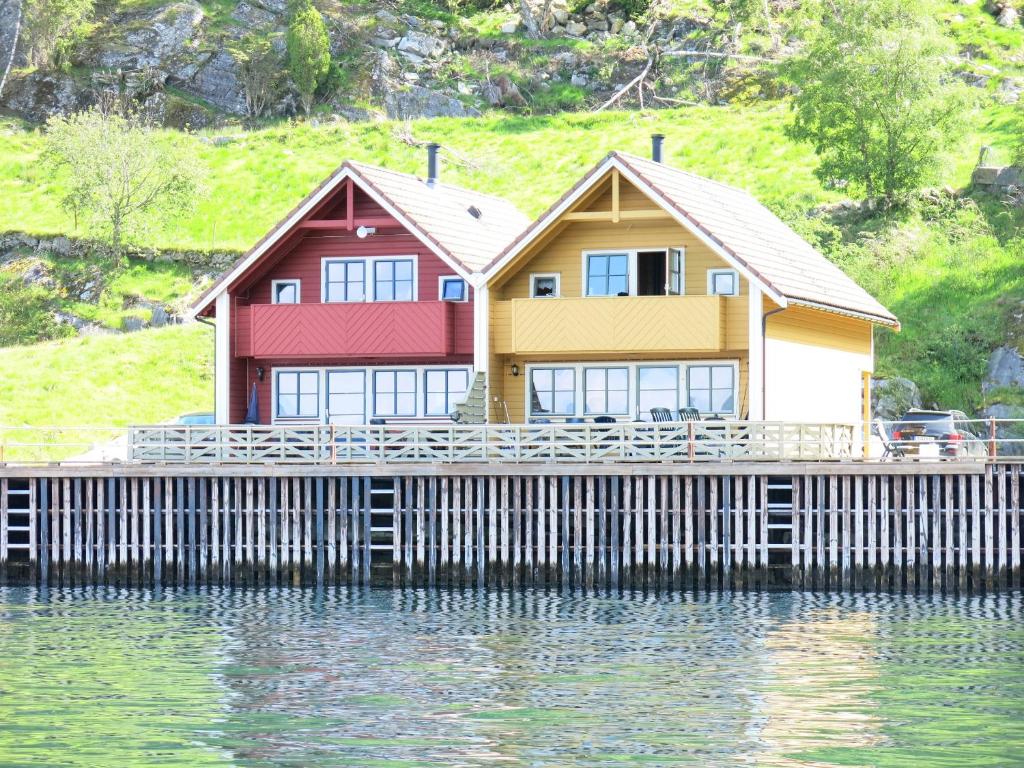 a house on a dock on a body of water at Fjordhytte-23 direkt am Sognefjord, mit mietbaren Motorbooten 9,9-60 PS in Bjordal