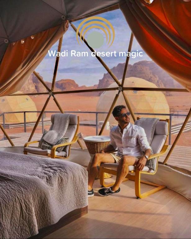 een man in een stoel in een tent bij Wadi Rum desert magic in Wadi Rum