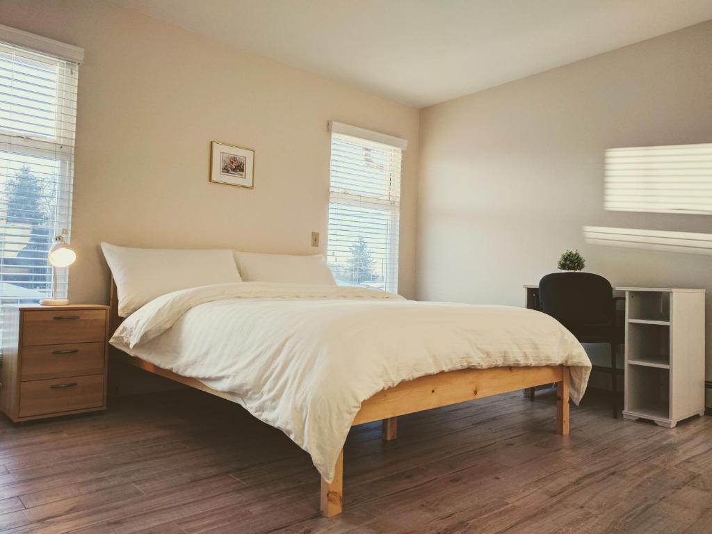 um quarto com uma cama grande e lençóis brancos em Burnaby lovely home em Burnaby