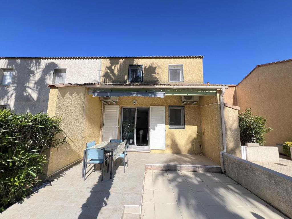 eine Terrasse mit Stühlen und einem Tisch vor einem Haus in der Unterkunft Maison Valras-Plage, 3 pièces, 5 personnes - FR-1-781-15 in Cité de la Raye Dieu