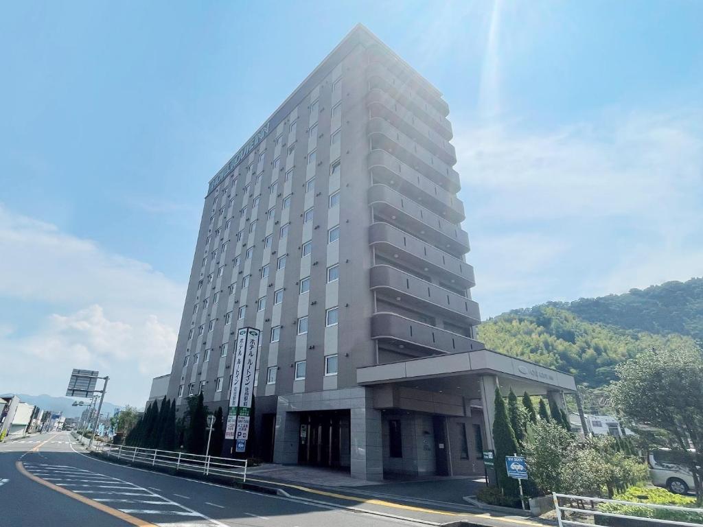 ein großes Gebäude an der Straßenseite in der Unterkunft Hotel Route-Inn Saiki Ekimae in Saiki