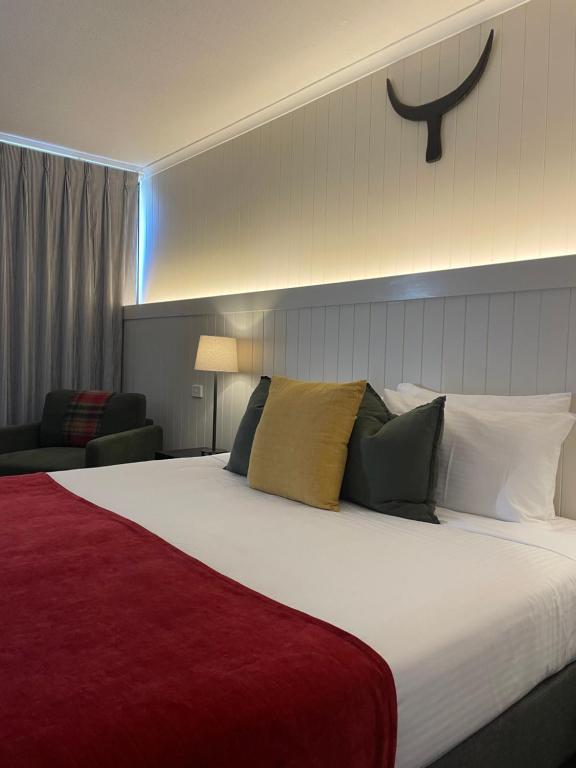 a bedroom with a large bed with a red blanket at The Black Bull Motel in Traralgon