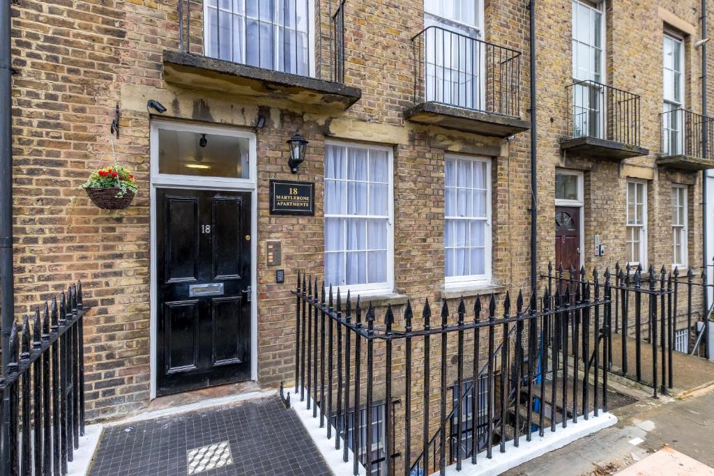 a black door on the side of a brick building at Marylebone Apartments in London