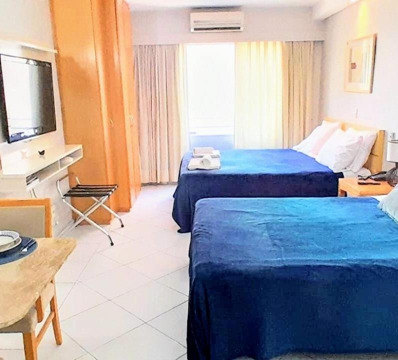 a hotel room with two beds and a television at Flat em frente ao Allianz Parque - Com Estacionamento in São Paulo