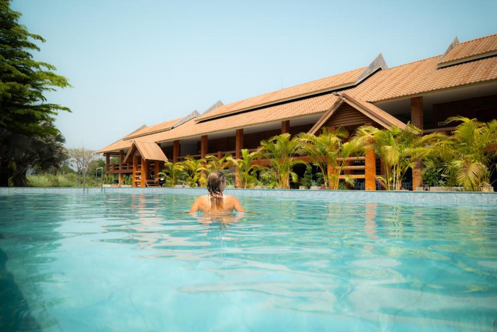 eine Person in einem Schwimmbad in einem Resort in der Unterkunft Vang Vieng Romantic Resort in Vang Vieng