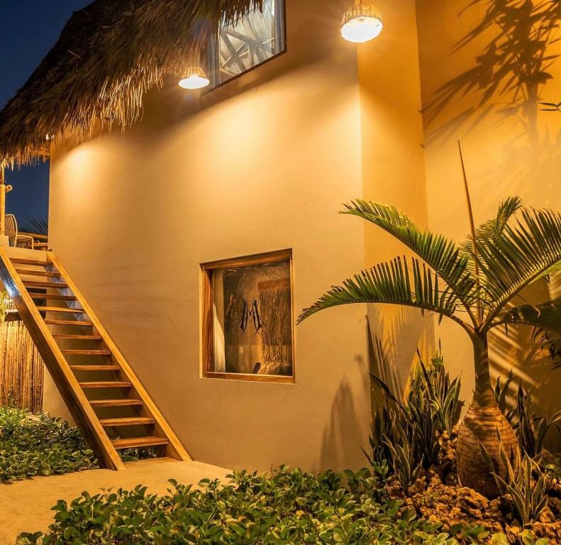 een huis met een trap en een palmboom ervoor bij Mare mío Hotel Boutique in Puerto Arista