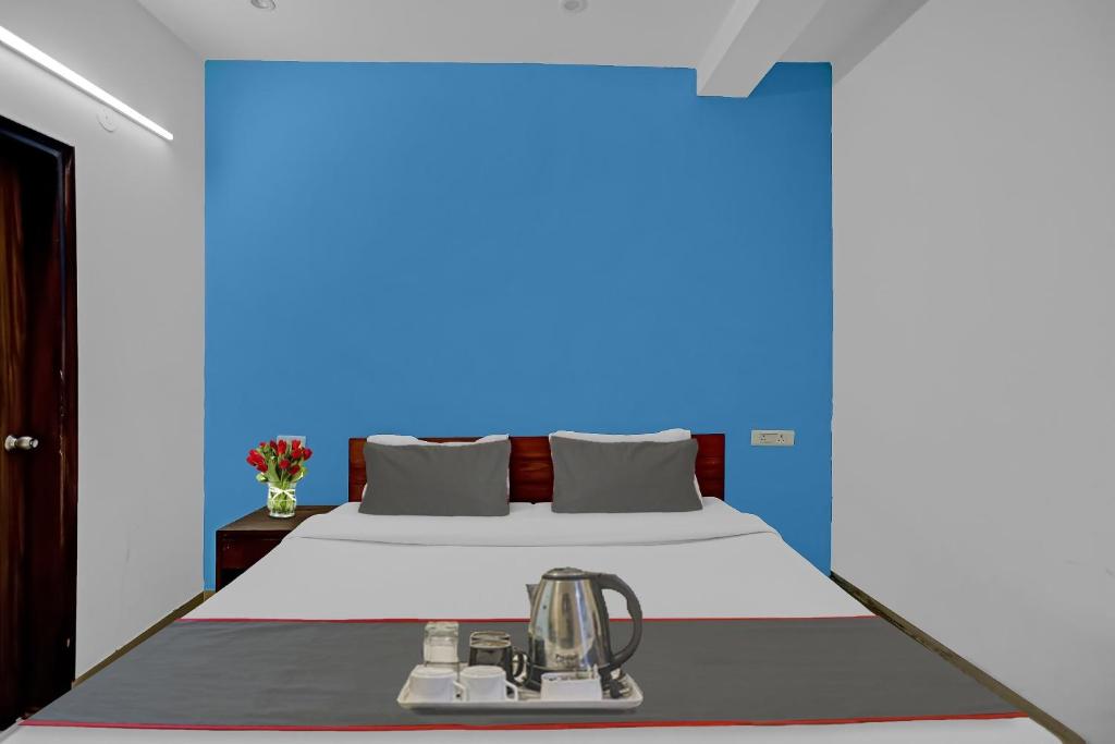 een bed in een kamer met een blauwe muur bij Collection O Hotel Daffodils in Gurgaon