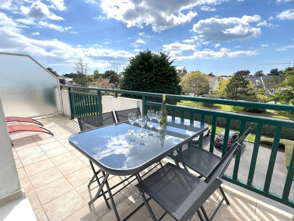 - un balcon avec une table et des verres à vin dans l'établissement Appartement rénové avec terrasse au Pouliguen, proche plage, port et commerces - FR-1-392-235, au Pouliguen