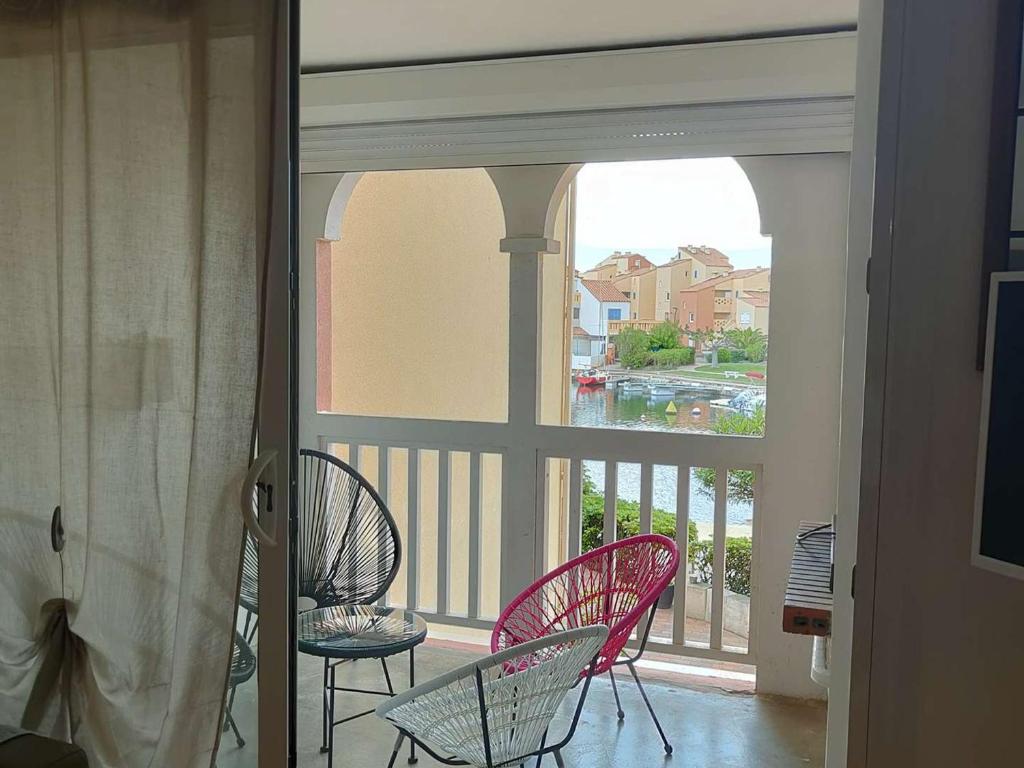 d'un balcon avec trois chaises et une fenêtre. dans l'établissement T2 Cabine avec Terrasse et Parking - Le Barcarès - FR-1-195-109, au Barcarès